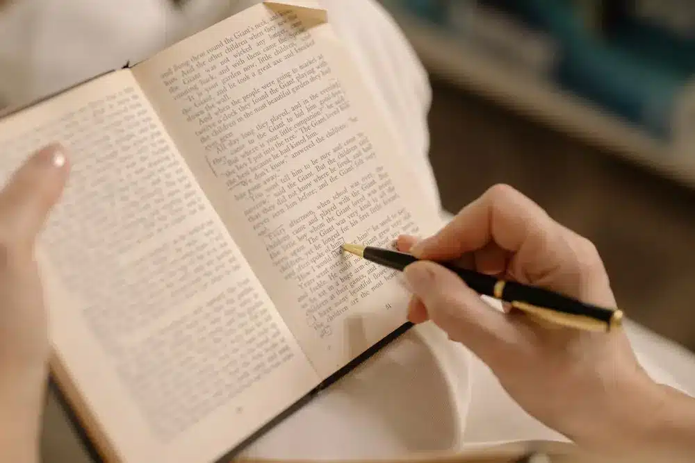 A student underlining a phrase in a book.